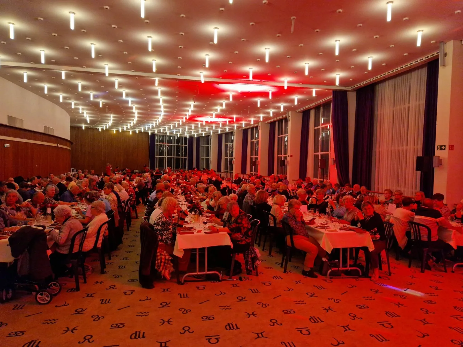 De feestzaal van het Kursaal vol gasten aan gedekte tafels tijdens het kerstfeest van 24 december 2025.